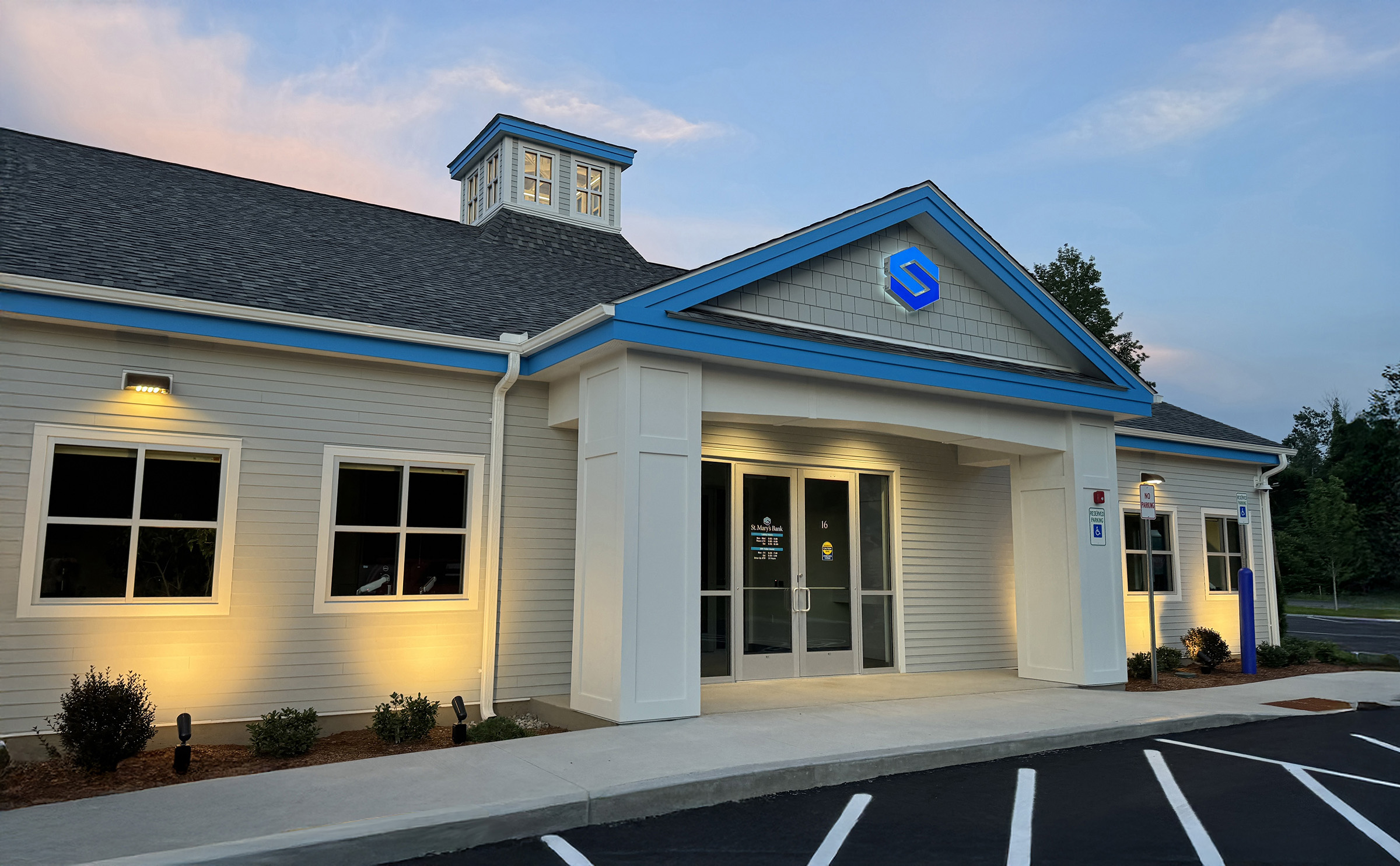 Exterior view of St. Mary’s Bank Concord branch at 2 Chenell Drive, Concord, New Hampshire, at dusk, showing the illuminated building and parking area.