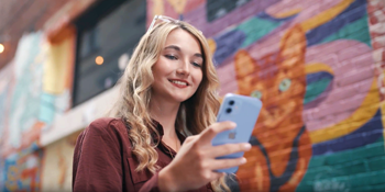 A woman using her St. Mary's Bank online banking app on her phone while she runs errands.