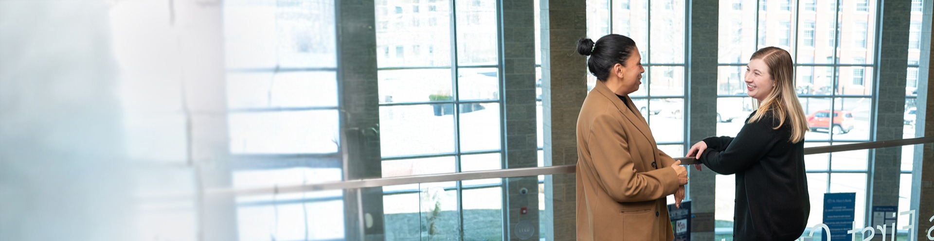 Two St. Mary's Bank Team Members stand on the second floor balcony of McGregor Street Branch